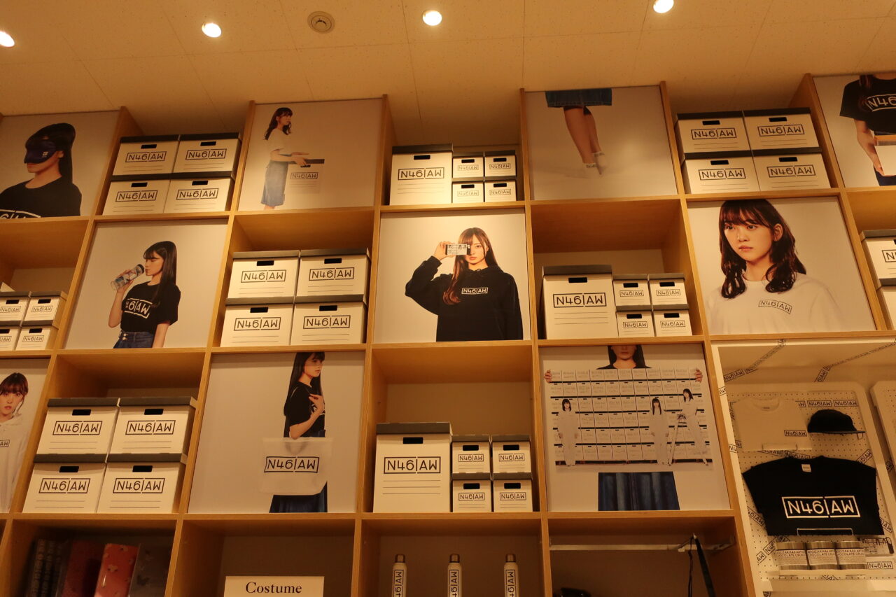 売店の中の様子。壁一面に商品が並べられている。また、乃木坂46の梅澤美波、西野七瀬らが商品を身につけている写真が貼られている。
