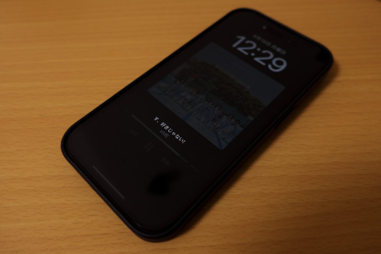 “常に画面オン”が有効で、薄く時計と再生中の曲名を常時表示しているiPhone 14 Proの写真