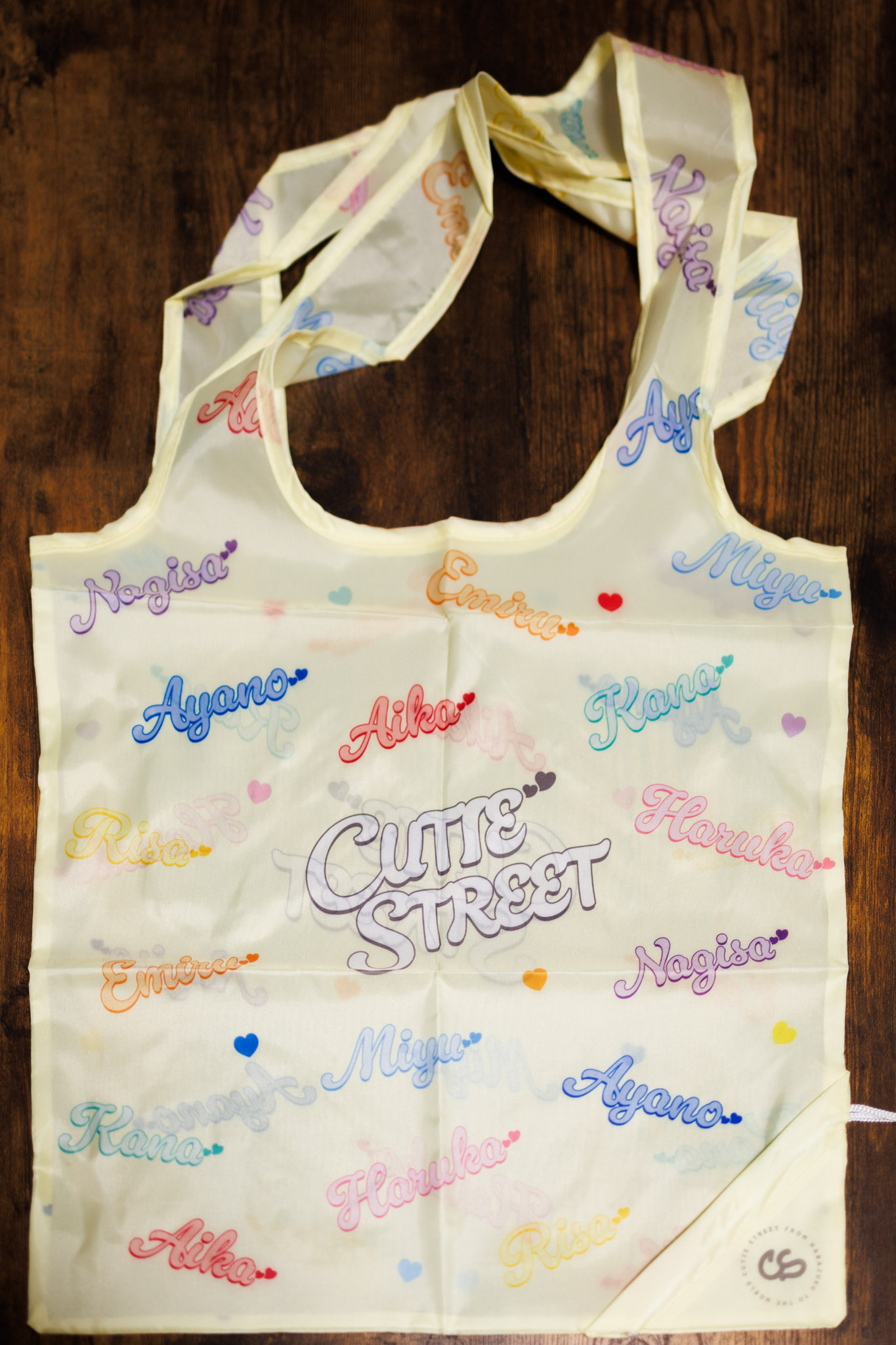 黄色の半透明なエコバッグに、“CUTIE STREET”とメンバー名の文字がカラフルにプリントされています。